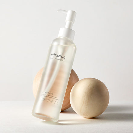 Skincare bottle labeled 'mixsoon' with wooden applicators on a light background