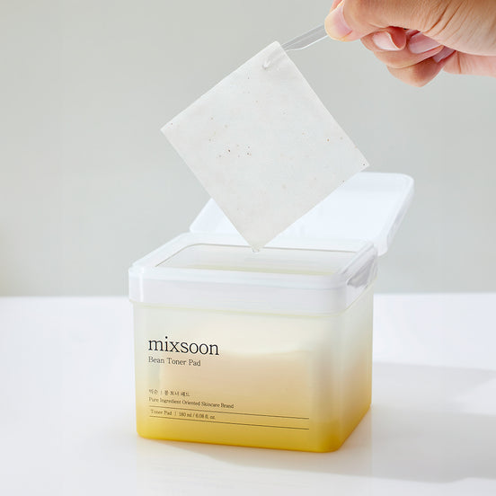 Hand pulling a toner pad from a container labeled 'mixsoon' on a white background