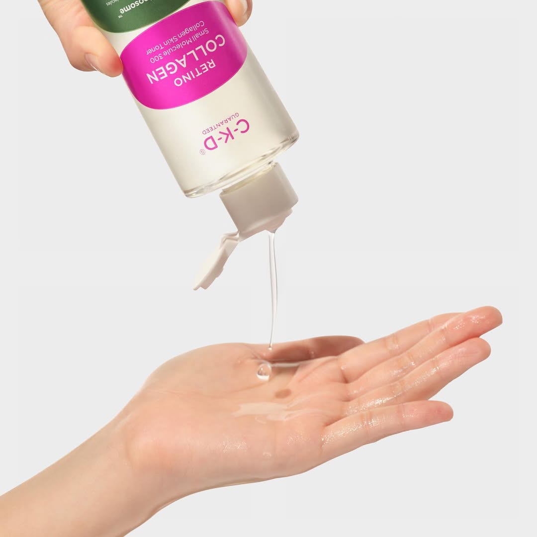 Hand holding a bottle of C+K Collagen product with liquid being poured onto a palm.