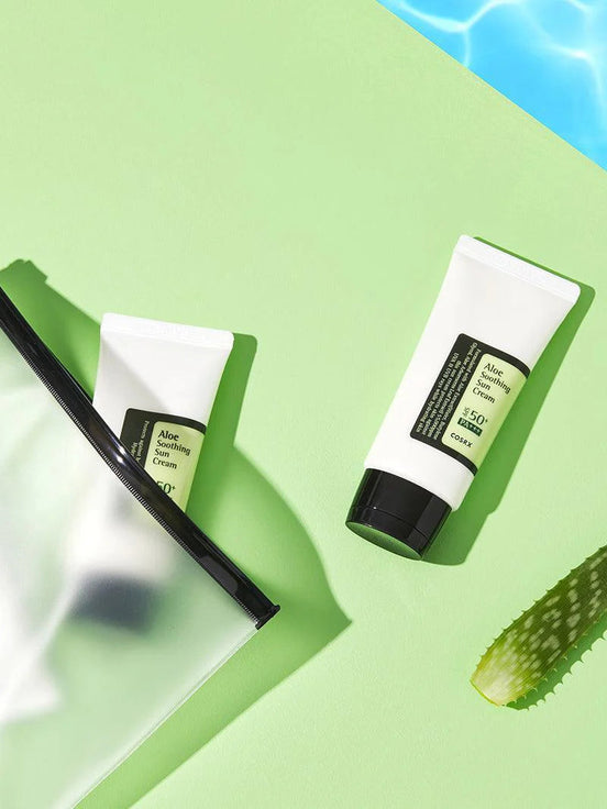 Two tubes of aloe vera cream on a green background with a slice of cucumber.